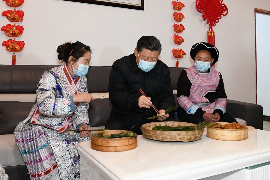 2021年2月3日下午，習(xí)近平在貴州畢節(jié)市黔西縣新仁苗族鄉(xiāng)化屋村苗族村民趙玉學(xué)家，同一家人邊聊家常邊制作當(dāng)?shù)貍鹘y(tǒng)節(jié)日食品黃粑。新華社記者 李學(xué)仁 攝